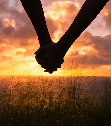 Couple Holding Hands At Sunset Stock Photo - Download Image Now ...