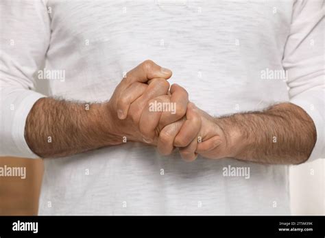 Man cracking his knuckles on blurred background, closeup. Bad habit Stock Photo - Alamy