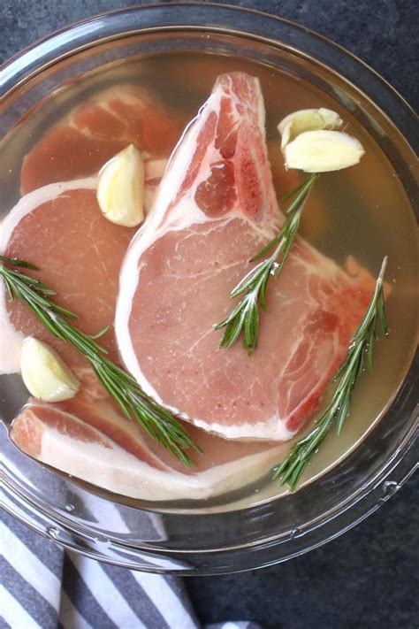 two raw meats in a glass bowl with herbs