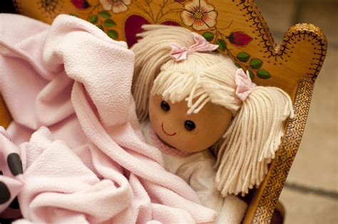 Free Stock Photo 11979 Doll Nestled Under Blankets in Wooden Cradle | freeimageslive