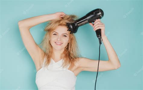 Premium Photo | Young woman using hair dryer drying hairstyle young attractive happy laughing ...