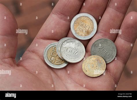 Colombian Peso Coins Held in HAnd Stock Photo - Alamy