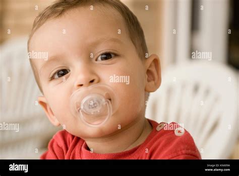 Baby boy one year old, smiling, with a dummy and wearing a red t-shirt, Spain Stock Photo - Alamy