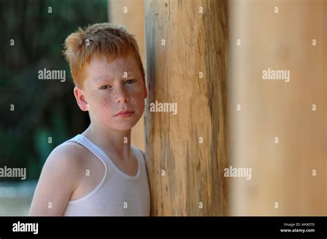 Sad boy at wooden door and post Stock Photo - Alamy