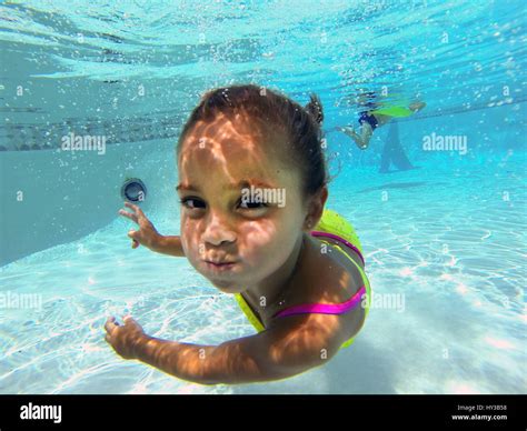 underwater in pool little girl poses to camera Stock Photo - Alamy