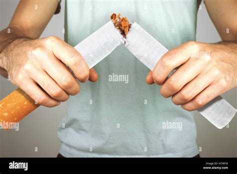 Quit smoking - male smoker breaking giant cigarette Stock Photo - Alamy