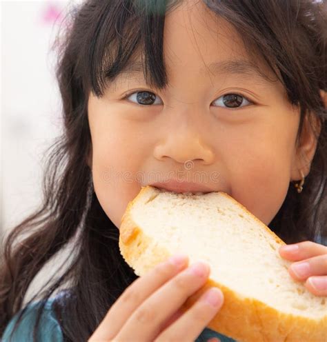 The Image of an Asian Girl with Long Black Hair Eating Natural Bread without Sugar for Health ...