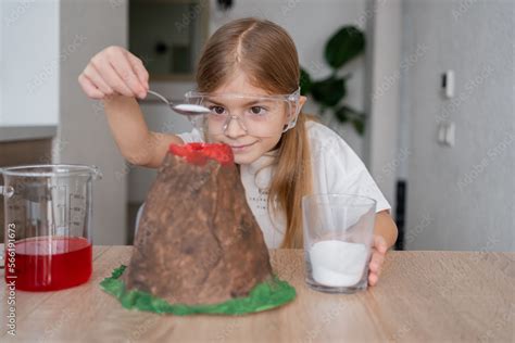 Kid science experiment of volcano or baking soda and vinegar volcano eruption for kid.Girl with ...