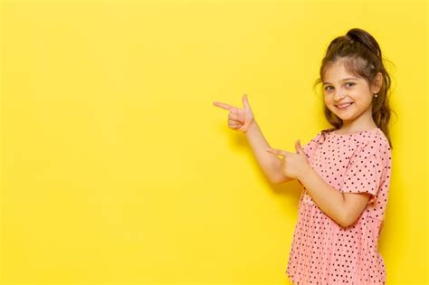 Free Photo | A front view cute little kid in pink dress smiling and pointing out