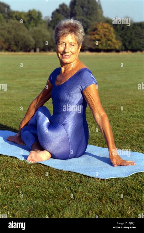 Mature female practising yoga outdoors. Yoga posture. Portrait image of older woman in yoga ...