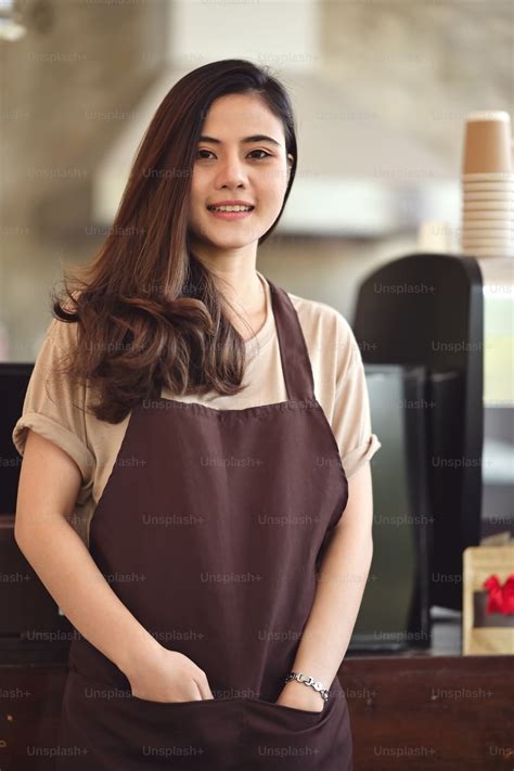 Portrait of attractive Asian barista woman standing at front of coffee bar counter. photo ...