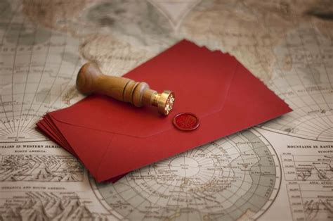 a red envelope with a wax stamp on it sitting on top of an old world map