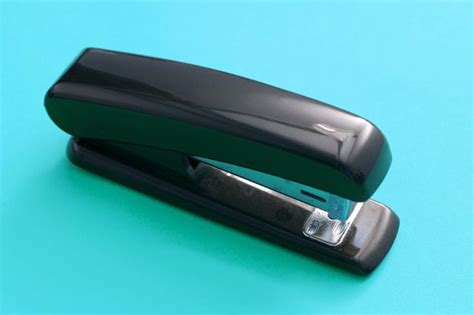 Free Image of Black Office Stapler Isolated on Blue Green | Freebie.Photography