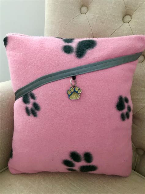 a pink pillow with black paw prints on it