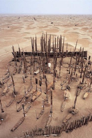 an old wooden structure in the desert surrounded by sand and dirt, with ...