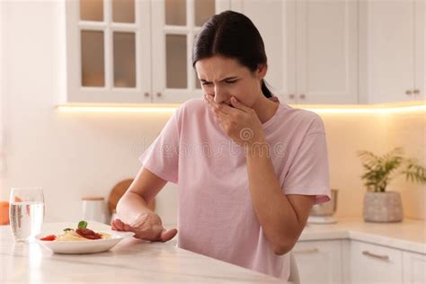Young Woman Feeling Nausea while Seeing Food at Table in Kitchen Stock Photo - Image of ...
