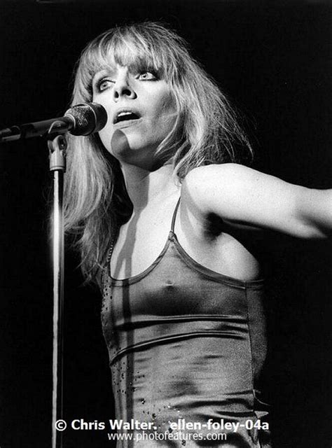 a black and white photo of a woman on stage with her arms out to the side