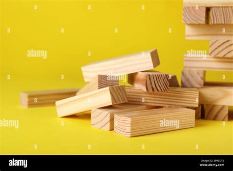 Wooden Jenga blocks on yellow background, closeup Stock Photo - Alamy
