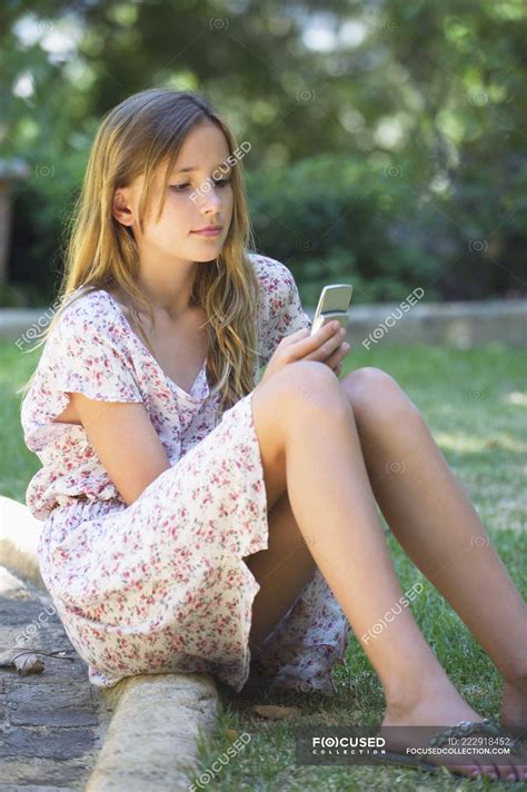 Cute teenage girl using a mobile phone in garden — Text Messaging ...