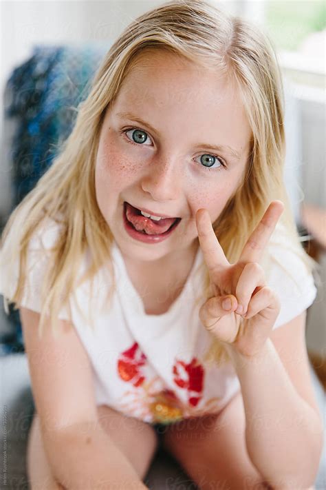 "A Little Girl Sticking Her Tongue Out And Making A Peace Sign." by Stocksy Contributor "Helen ...