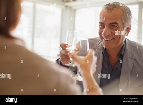Smiling senior man drinking wine, toasting wine glasses with woman at restaurant Stock Photo - Alamy