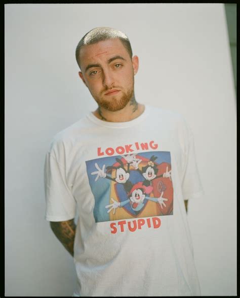 a man wearing a mickey mouse t - shirt looking at the camera with an angry look on his face