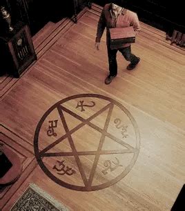 a person walking on a wooden floor with a pentagramus symbol in the middle
