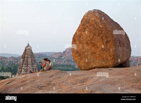 Tourists watching the sunset on Hemakuta Hill in Hampi Stock Photo - Alamy