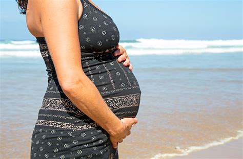 Happy pregnant woman on the beach at the atlantic ocean – Greens First Female