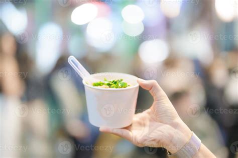 woman hand holding Rice Noodle in paper bowl at Ximending night market, famous Taiwanese Street ...