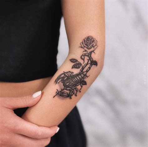 Scorpion and flower tattoo located on the arm.