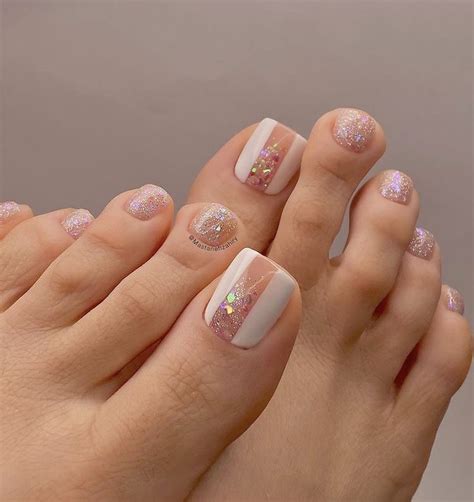 a woman's feet with pink and white nail polishes on them, while the ...