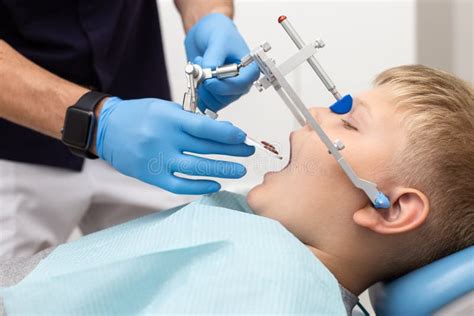 Little Boy Keep His Mouth Wide Open while His Dentist Setting Up Orthodontic Arch Stock Photo ...