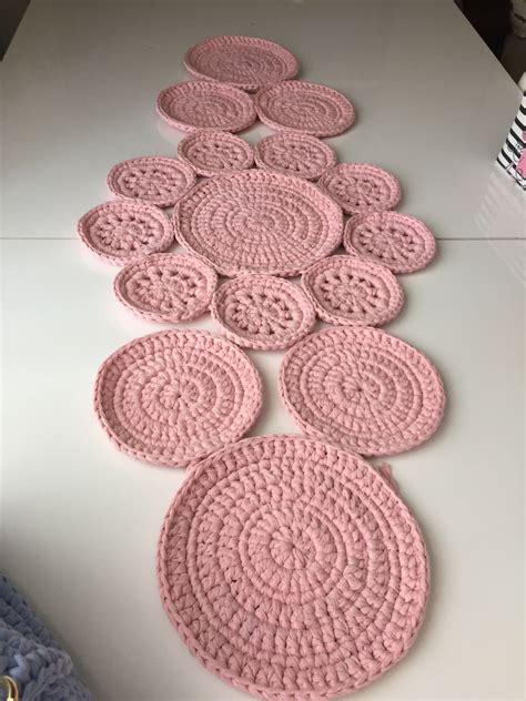 pink crocheted coasters laid out on a white countertop in the shape of circles
