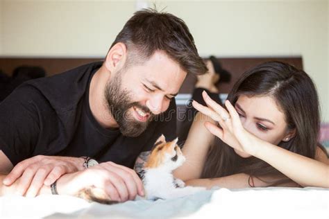 Beautiful Young Inlove Couple on the Bed Playing with a Kitten Stock ...