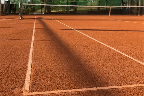 Cancha de tenis de arcilla (tierra), bajo la puesta de sol. | Foto Premium