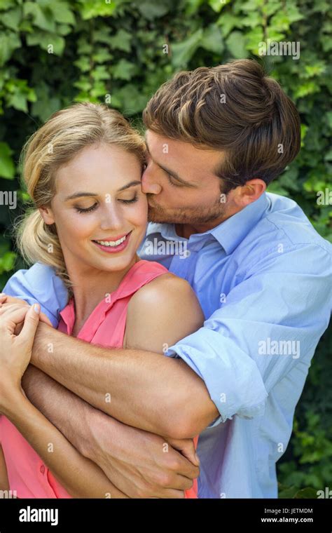 Romantic man kissing woman at front yard Stock Photo - Alamy