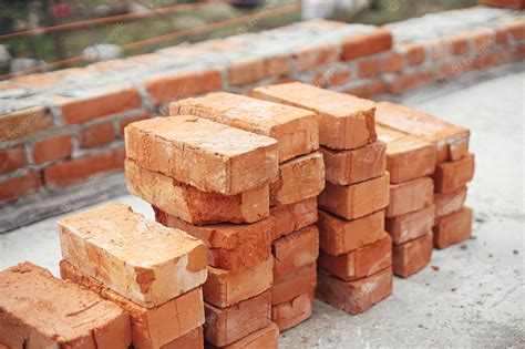 Premium Photo | Stack of red bricks on concrete foundation process of house building Concrete ...