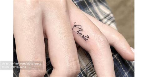 Tattoo of the name "Charlie" located on the finger.