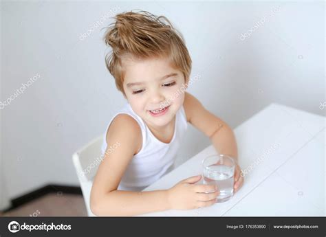 Funny Little Boy Sitting White Table Glass Water Stock Photo by ©BatkovaElena 176353890