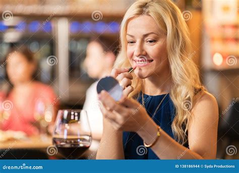 Woman with Lipstick Applying Make Up at Restaurant Stock Photo - Image of middleaged, coloring ...