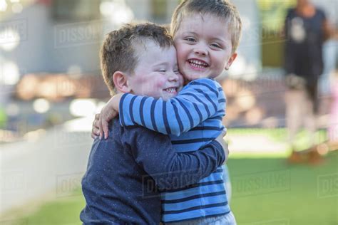 Two young boys, outdoors, hugging - Stock Photo - Dissolve