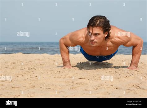 Muscular man during workout on the beach Stock Photo - Alamy