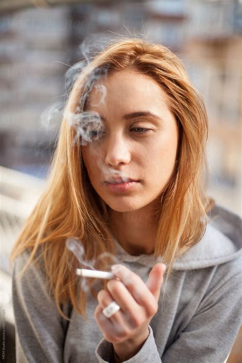 "Attractive Young Woman Smoking Cigarette" by Stocksy Contributor "MEM Studio" - Stocksy