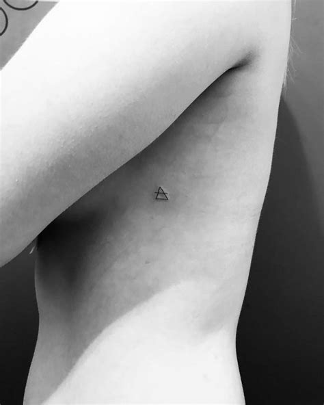 Transcend symbol tattoo on the sideboob.