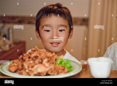 Boy looking at fried chicken, Japan Stock Photo - Alamy