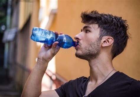 Handsome Young Man Drinking Water from Bottle Stock Photo - Image of ...