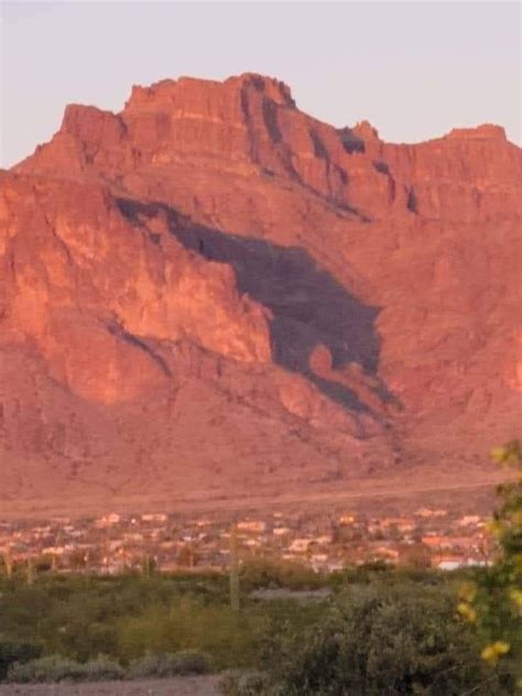 This shadow on the Superstition Mountains, Apache Junction, AZ, the cougar, only appears twice a ...