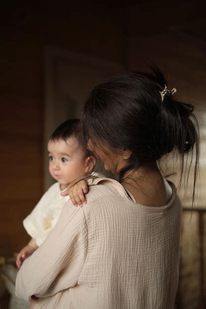 Premium Photo | Nurturing connection a delighted mom lovingly embraces her baby girl both garbed ...