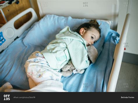 Little girl lying in a hospital bed stock photo - OFFSET